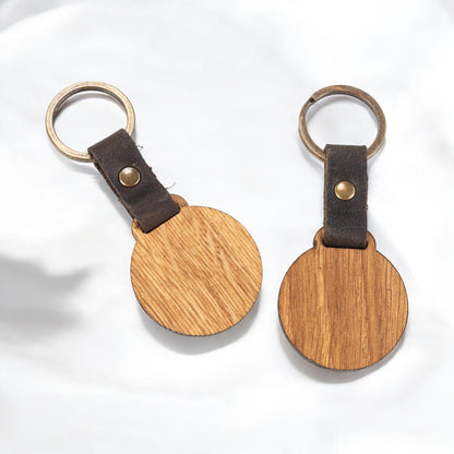 Nyckelring i trä av oljad ek med mörkbrun läderrem